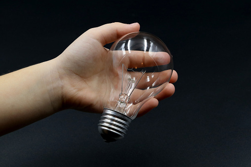 Child's hand holding a light bulb