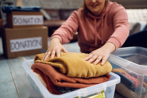 primer plano de la mujer preparando una caja de ropa para la caridad. - manta fotografías e imágenes de stock