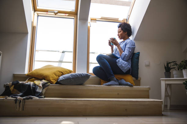 istock Taking a sip of morning coffee while relaxing on the window sill and reading a book 1388314190