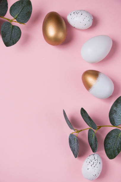 istock Easter eggs with green eucalyptus branches on a pink background. Holiday concept. Happy Easter greeting card 1388315502