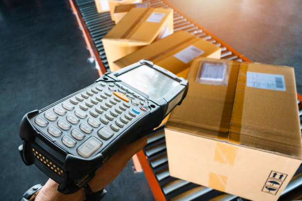istock Workers Scanning Bar Code Scanner with Packaging Boxes on Conveyor Belt. Shipping Supplies Warehouse. Computer Mobile Work Tools for Inventory Management. Storehouse. Shipment Pacel Boxes. 1388317845