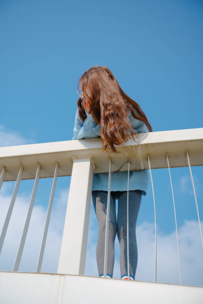 A beautiful asian girl leaning on a railing