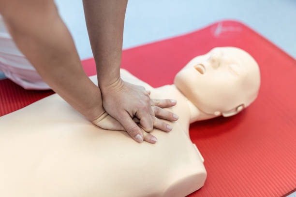 istock CPR class with instructors talking and demonstrating firt aid, compressions ans reanimation procedure. Cpr dummy 1388321158