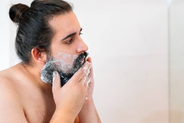 istock young man with bushy beard, spreading shaving foam. 1388322768