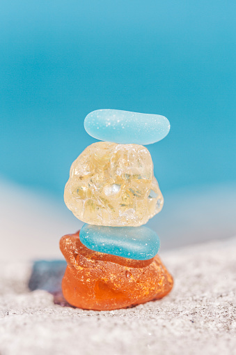 Macro shot of zen sea glass stone balance stack by the ocean.  The act of balancing stones carries with it a practice of patience and a physical effort of creating balance and calm
