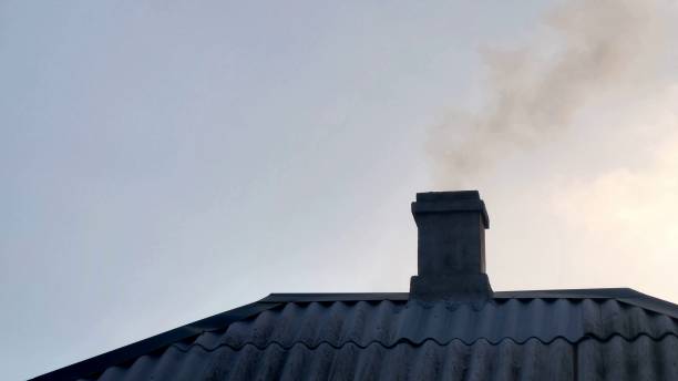 istock Light smoke from a chimney at sunset against a gray sky 1388323149
