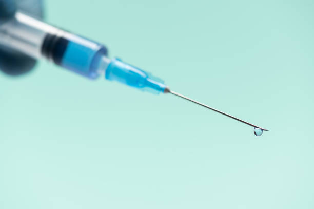 Close-up vaccine vial dose. Medical concept vaccination, fight against virus Close-up vaccine vial dose. Medical concept vaccination, fight against virus covid 19 corona virus. Close-up syringe needle with a drop on the tip diabetes epidemiology stock pictures, royalty-free photos & images
