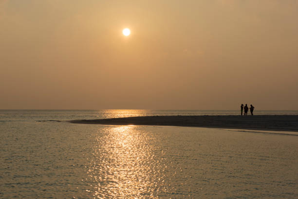 Panoramic view of beautiful remote tropical sandy beach on tropical ocean at sunset with reflection