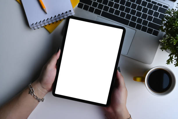 istock Overhead view young woman Hans holding mockup digital tablet with blank display. 1388324855