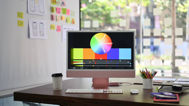 istock Designer working desk with modern computer, stationery and wireframe sketches of screens for mobile application on white board. 1388324937