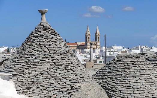 Sunny impression of trulli houses at a town named Alberobello in Apulia, Italy
