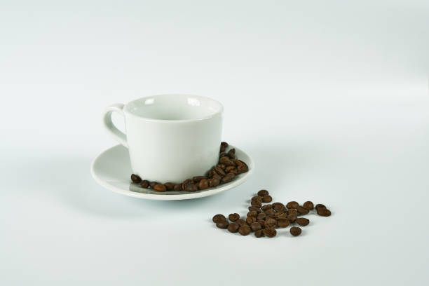 istock White coffee cup and coffee beans on a white background. With a place for text: the concept of a coffee shop 1388330698