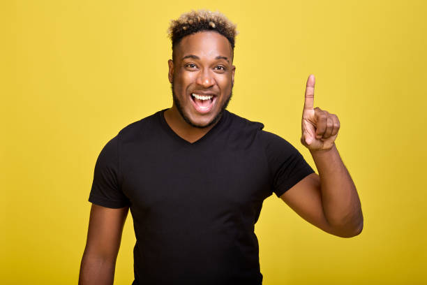 istock On a yellow background stands a popular black guy with a smile on his face 1388331773