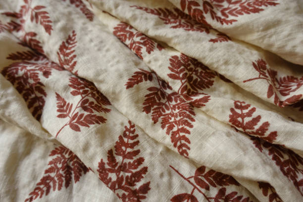 istock Folded beige linen fabric with brown fern leaves print 1388331908