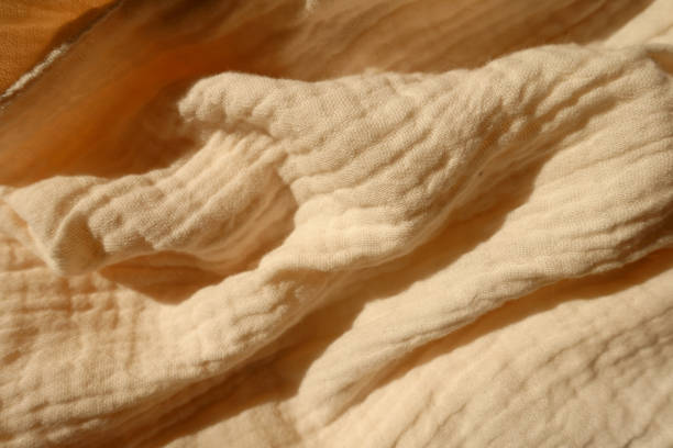 istock Crumpled thin pastel beige cotton muslin fabric 1388332431