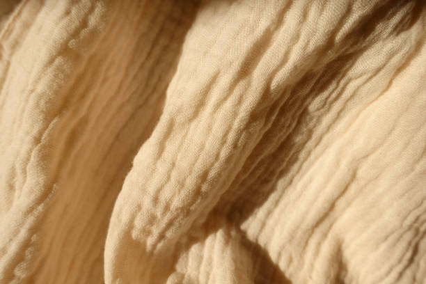 istock Folded thin pastel beige cotton muslin fabric 1388332529