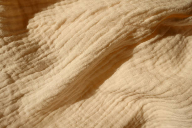 istock Diagonal soft fold on thin beige cotton muslin fabric 1388332531