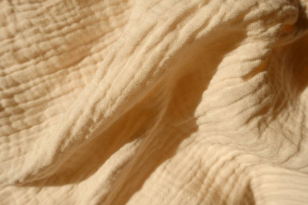 istock Soft folds on thin beige cotton muslin fabric 1388333152