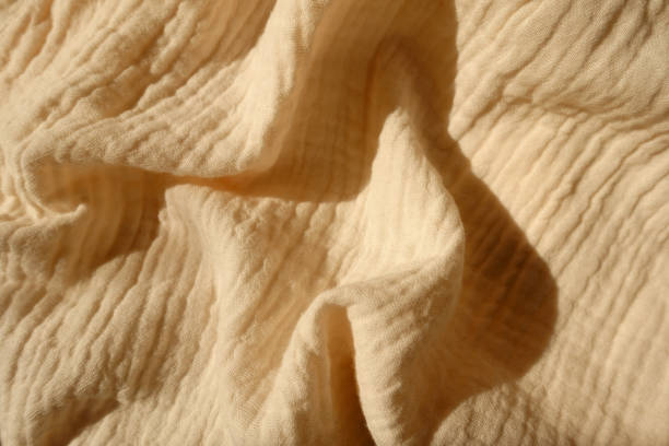 thin beige cotton muslin fabric in soft folds