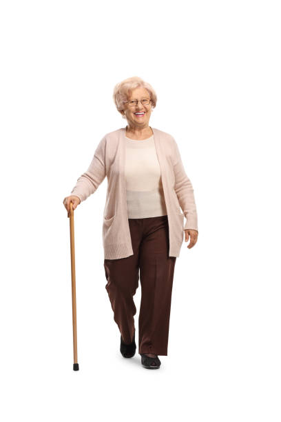 istock Smiling elderly woman walking towards camera with a cane 1388338009