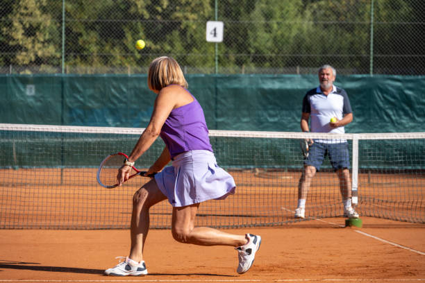 pareja jugando en cancha de tenis - tennis couple women men fotografías e imágenes de stock