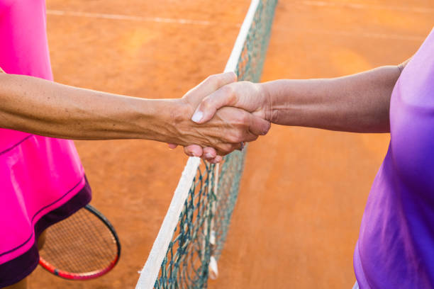 istock Shaking hands on clay court 1388338530