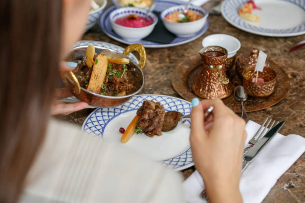istock Pouring meat dish from copper bowl with spoon at the restaurant table 1388340817