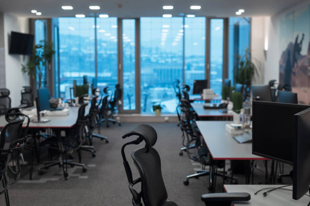 istock Front view of coworking office interior with workplaces, blank picture frame on wall and computer 1388343752