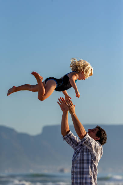 istock Father playing with her daughter on the beach 1388345366