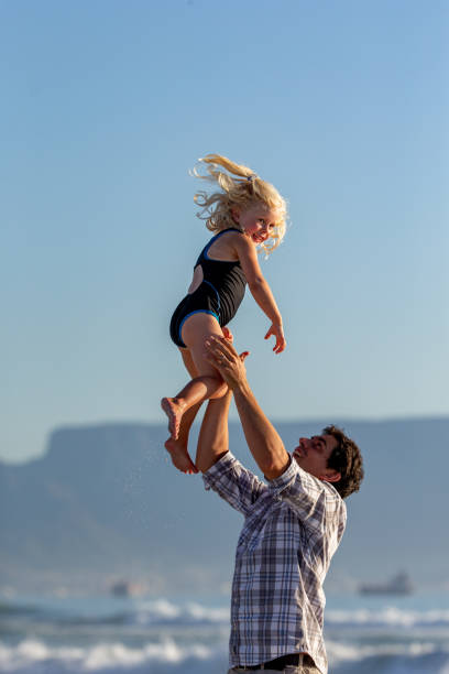 istock Father playing with her daughter on the beach 1388345374