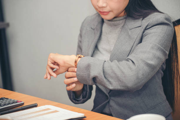 istock Time out concept. Urgent work, business woman seeing wrist watch and using mobile phone before meeting. Smart woman check the schedule before going to the office. Time out for appointment meeting 1388348880