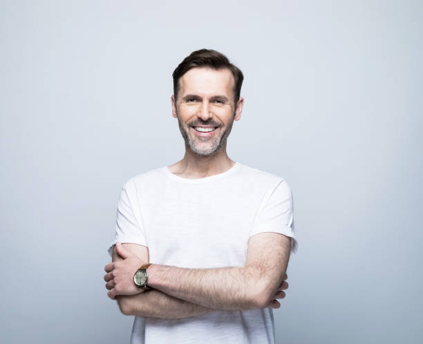 istock Smiling handsome man standing with arms crossed 1388349778
