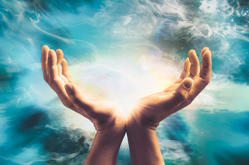 Close up of conceptual hand sending cosmic healing energy to universe.
