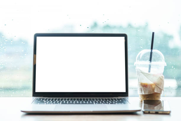 istock Mockup of laptop computer with empty screen with coffee and smartphone isolate on wooden office desk in coffee shop like the background ,White screen 1388355520
