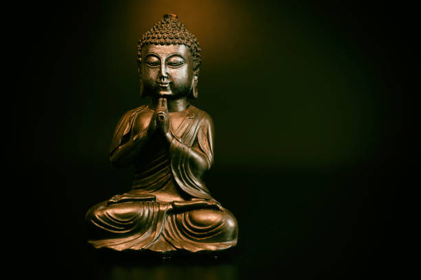 istock Buddha in atmospheric dark lighting with side light and selective focus 1388355766