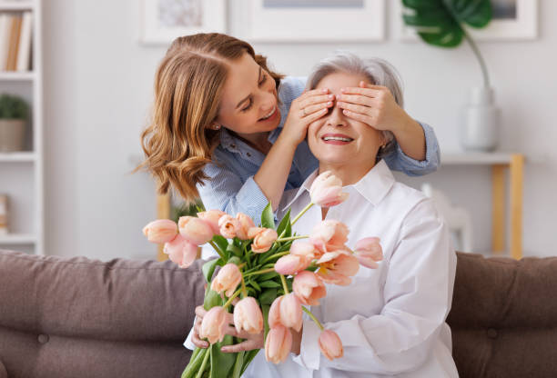 新鮮なチューリップの花束で喜んだ若い女性はおめでとう母 - grandmother senior adult smiling women ストックフォトと画像