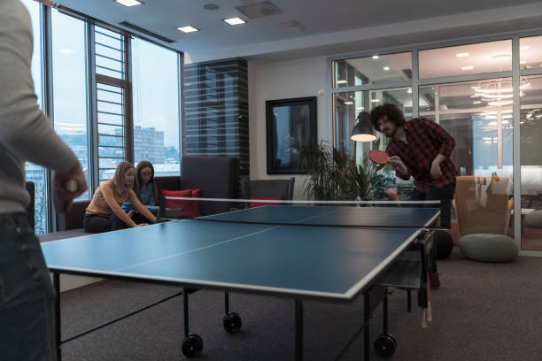 istock Two young start up business man playing ping pong tennis at modern creative office space people group have meeting and brainstorming in background 1388361656