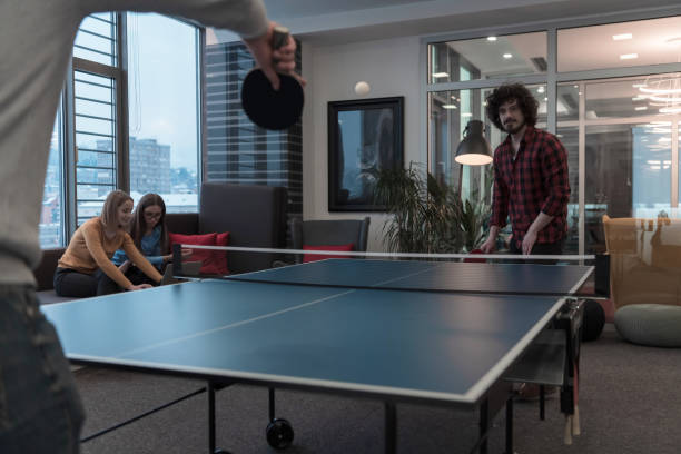 istock Two young start up business man playing ping pong tennis at modern creative office space people group have meeting and brainstorming in background 1388363163