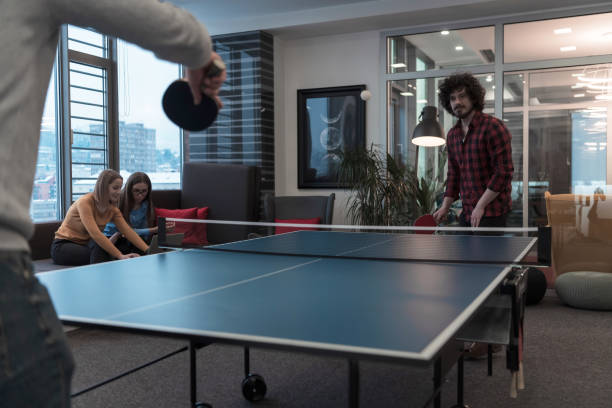 istock Two young start up business man playing ping pong tennis at modern creative office space people group have meeting and brainstorming in background 1388364417