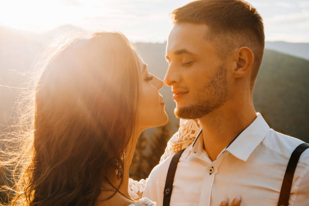 istock Pretty groom kissing gorgeous bride in sun light, perfect moment, boho wedding couple 1388364607