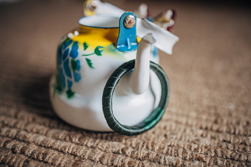 Bracelet on teapot on the floor.