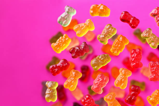 istock Multicolored flying gummy bears on a pink background, flat lay 1388366330