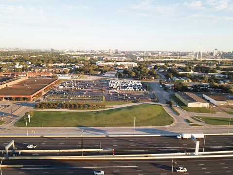 Business park and industrial zone along I-30 Tom Landry Freeway west of downtown Dallas with Margaret Hunt Hill Bridge in background. Shell industrial building large outdoor parking lots