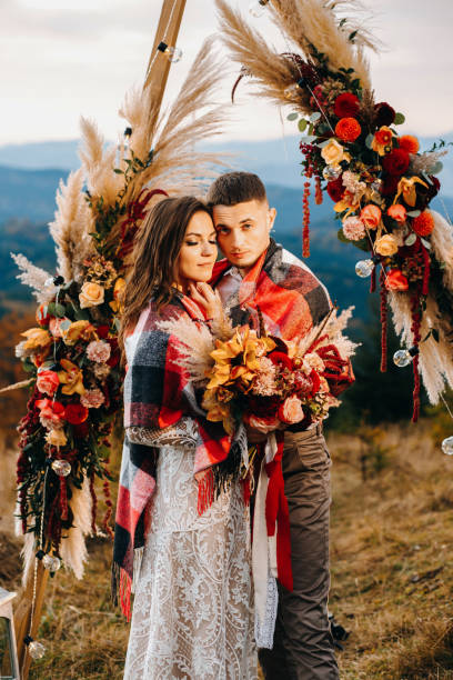 istock Amazing groom hugs bride's  they stand before wedding altar at evening 1388367617