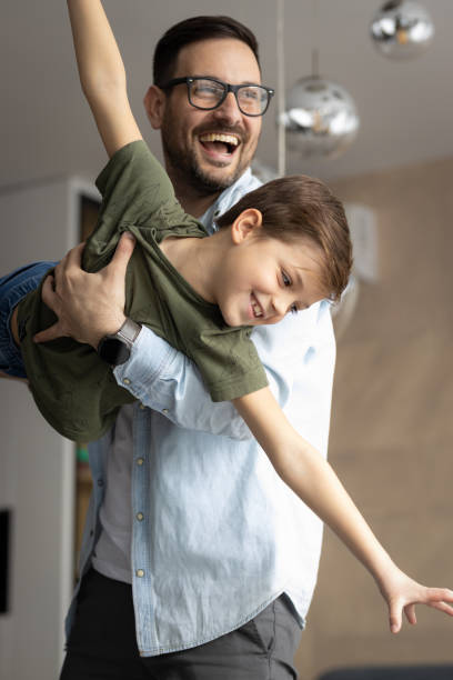 Father and son having fun in the living room stock photo