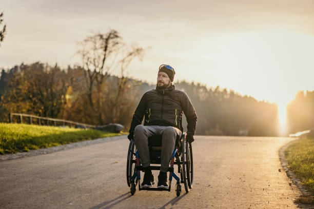 Disabled man in wheelchair on road stock photo