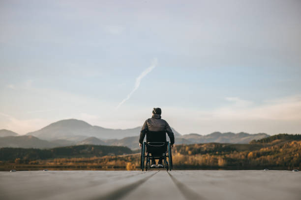 istock Paraplegic in wheelchair on pier at sunset 1388369016