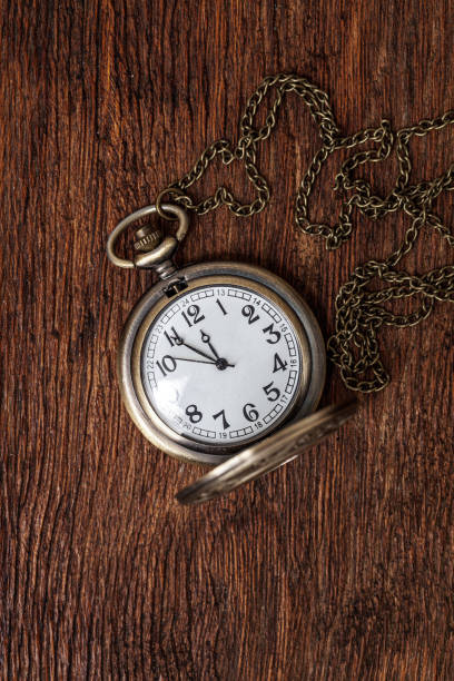 istock Vintage copper pocket clocks on dark wood background 1388369421
