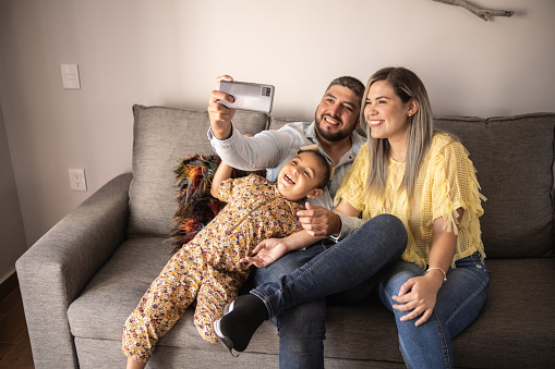 Family taking selfies or doing a video call at home