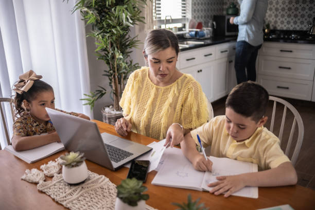 istock Latin mother working and helping son with homework at home 1388371580